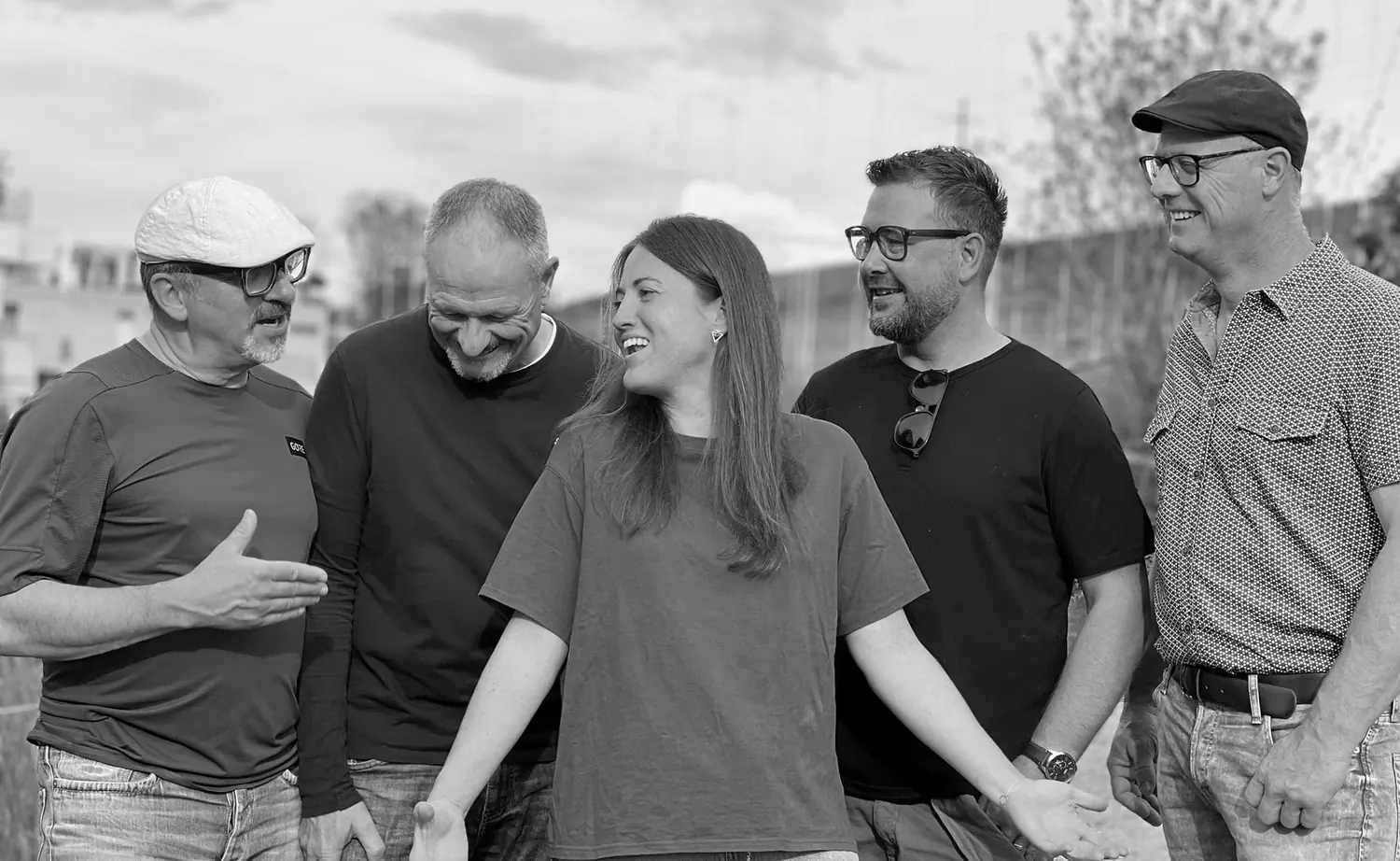 Die fünf Bandmitglieder lachend auf einer Dachterrasse, Schwarz-Weiss